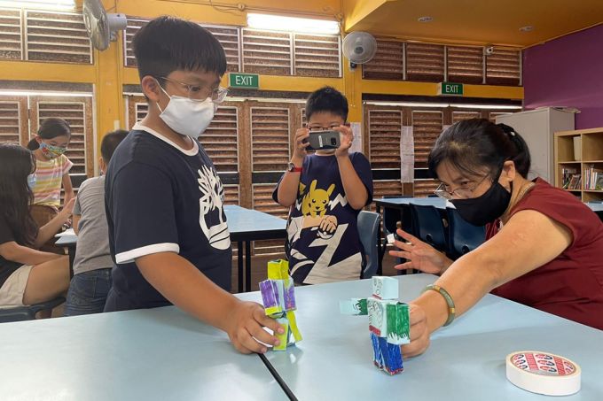 Children at Morning Star Community Services animating their paper robots with the help of a student-care teacher using a stop motion videography app on the smartphone. PHOTO: TRCL